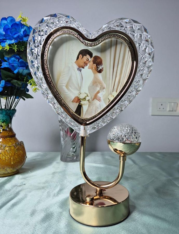 Heart-shaped crystal-cut photo frame on a gold stand